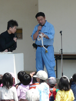 春の動物と花のフェステイバルでヘビを手に説明